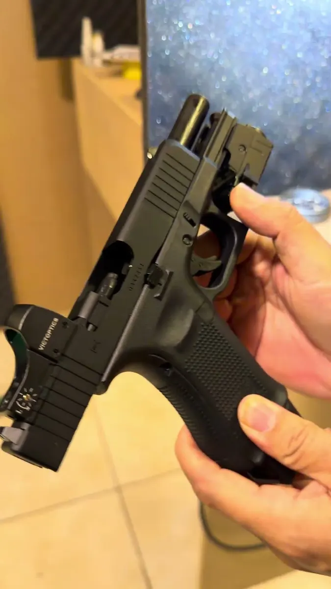 Pistola de pressão estilo Glock na mão do atendente